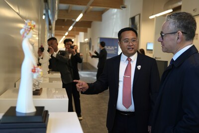 Photo taken on Feb. 24 shows Fang Junqin, Party Chief of Dehua County in southeast China's Fujian Province introducing Dehua white porcelain exhibits to foreigners in Palais des Nations in Geneva, Switzerland. (PRNewsfoto/Xinhua Silk Road)