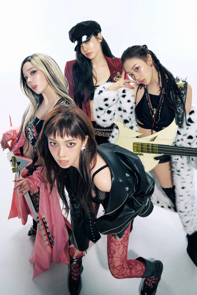 aespa together, dressed in stylish rock-themed outfits. They are holding guitars and exhibiting a confident, edgy attitude against a plain white backdrop.