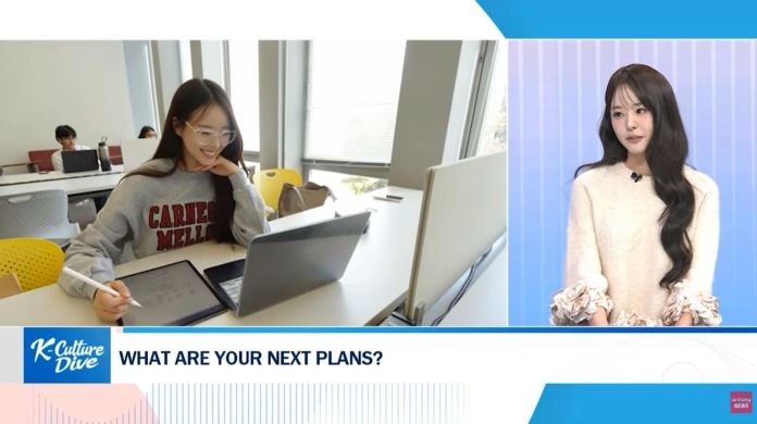 A student smiling while working on a laptop with a tablet in a study area, complemented by an on-screen interview segment featuring a woman in a light sweater.