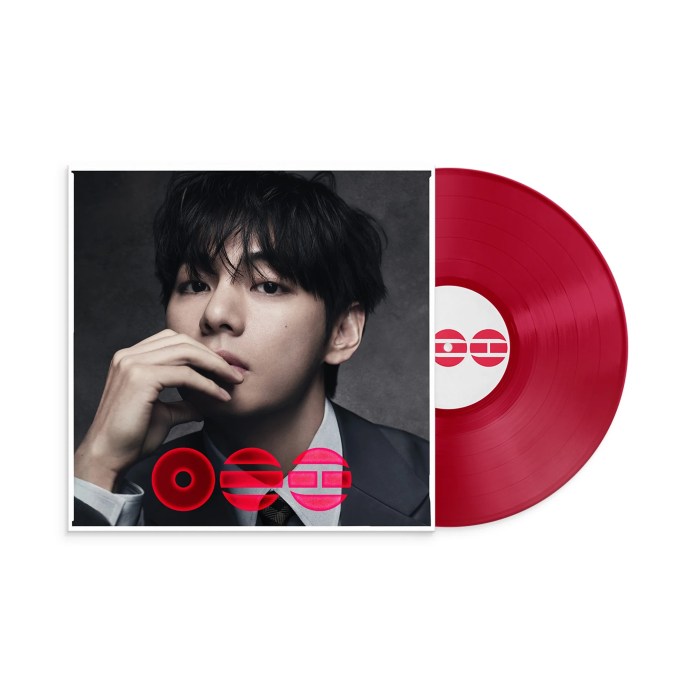 A red vinyl record next to an album cover featuring a close-up of a young man with dark hair, wearing a suit, resting his chin on his hand.