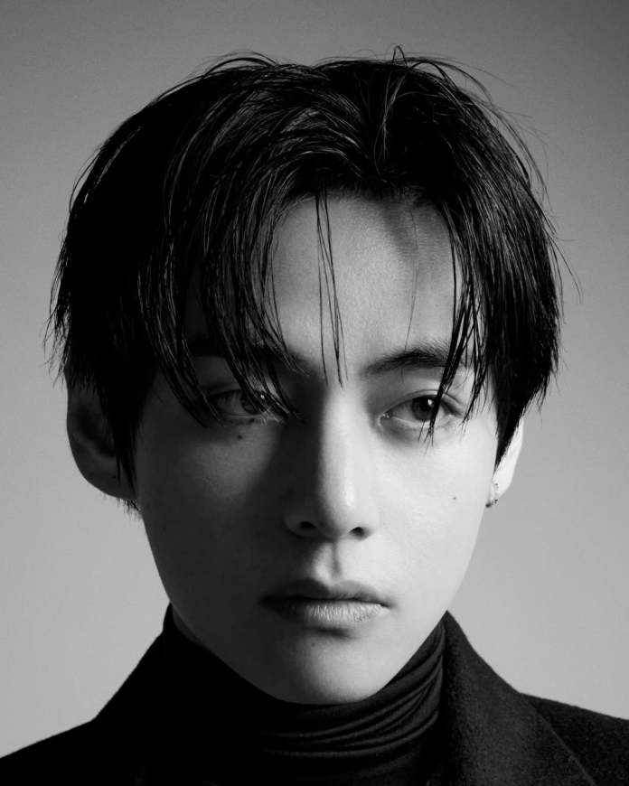 Close-up portrait of BTS V with dark hair styled in a modern, textured look, wearing a high-necked black top against a muted background.