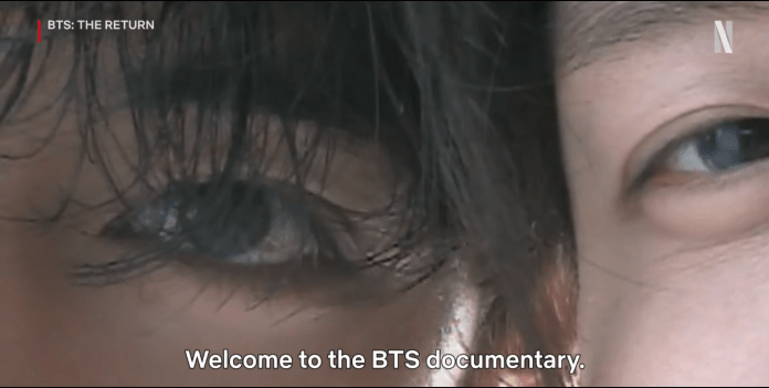 Close-up of two eyes with hair partially covering them, featuring the text 'Welcome to the BTS documentary.'
