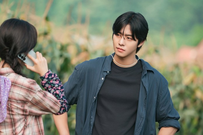Ahn Hyo Seop engaged in a conversation outdoors, with one person holding a phone and the other looking intently.