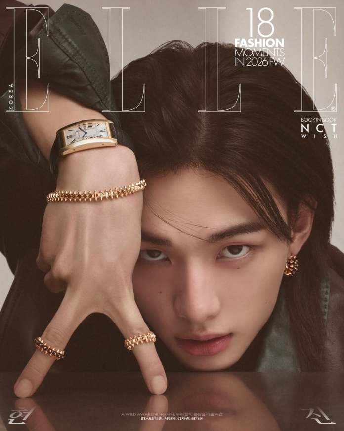Close-up portrait of Hyunjin showcasing intricate hand gestures and fashionable accessories, including rings and a watch, set against a subtle background.