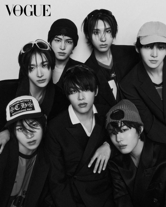 KickFlip dressed in stylish black blazers and hats, posing closely together in a black and white photograph. The image captures a modern, fashionable aesthetic, likely for a fashion magazine cover.