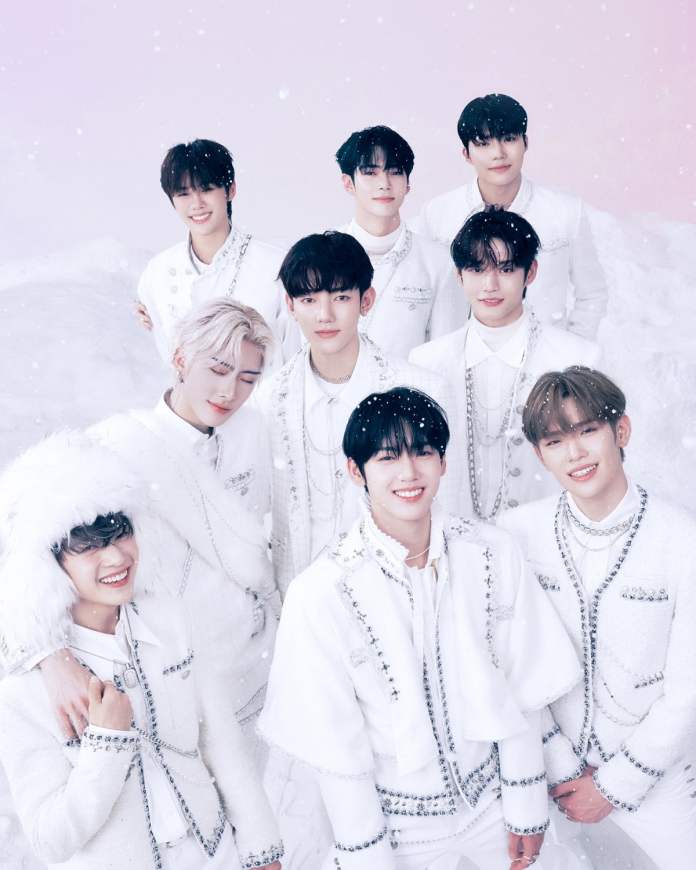 ZEROBASEONE dressed in matching white outfits, standing together in a snowy setting with a pastel pink background.