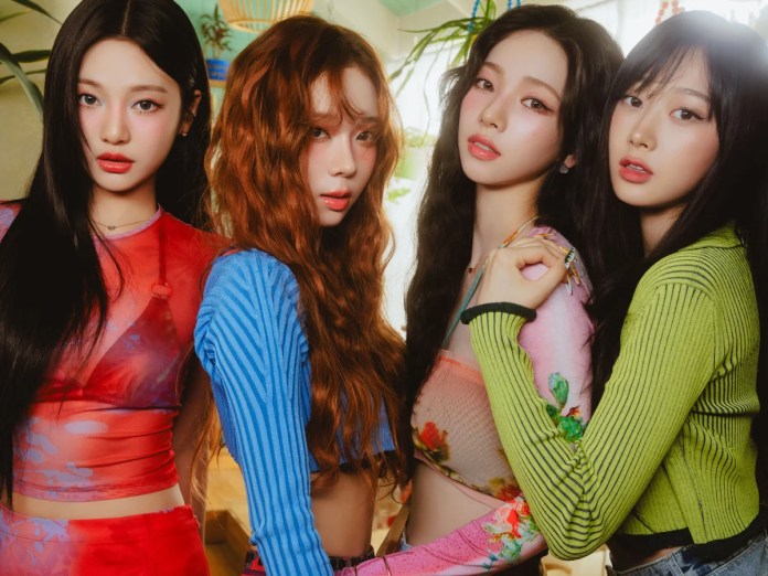 aespa posing together in a vibrant, brightly lit indoor setting, wearing colorful outfits with various patterns.