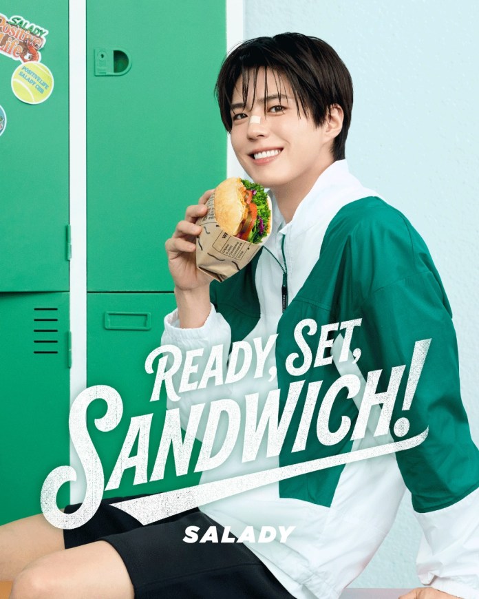 Park Bo-gum smiling while holding a sandwich in front of a green locker, dressed in a sporty outfit, with the text 'READY, SET, SANDWICH! SALADY' prominently displayed.