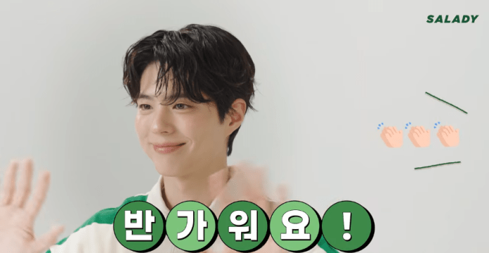 A smiling Park Bo-gum with tousled hair is waving, accompanied by playful text and clapping emojis.