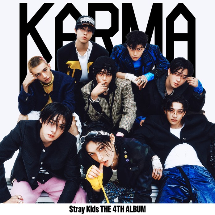 A group of eight male musicians from the K-pop group Stray Kids poses for their 4th album, titled 'KARMA', featuring a stylish and trendy aesthetic with a mix of outfits.