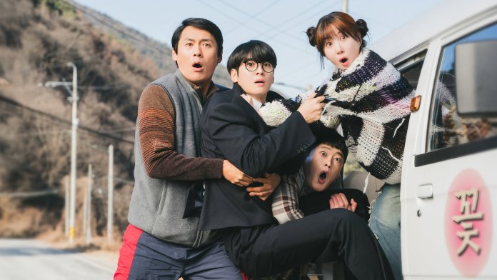 The cast of Wonderfools, Park Eun-bin and Cha Eun-woo reacting with surprise and fear, crowded around a vehicle along a roadside with hills in the background.
