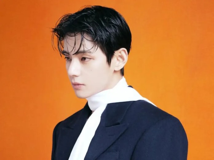 BTS V with dark, slicked-back hair is depicted in profile against an orange background. He wears a dark tailored jacket with a white scarf, showing a contemplative expression.