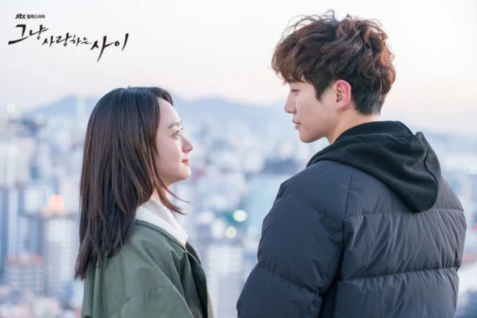 A romantic scene featuring Lee Junho gazing at each other against a city skyline during twilight.