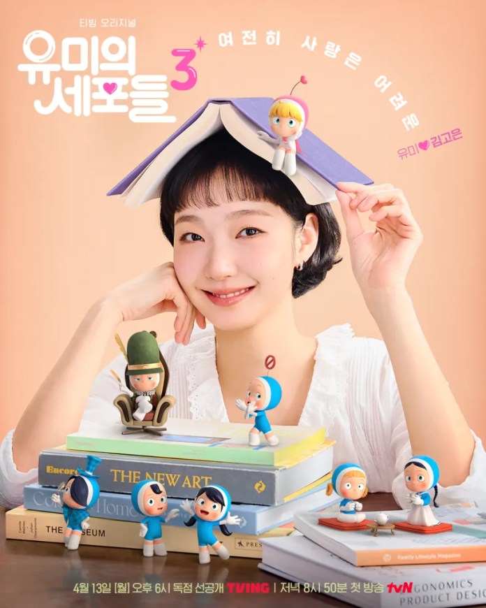 Kim Go-eun  smiling while holding a book on her head, surrounded by colorful figurines and stacks of books, promoting a TV series.