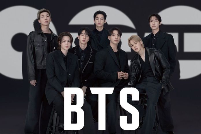 A group photo of BTS, a seven-member K-pop band, standing together in stylish black outfits against a dark background with prominent branding.