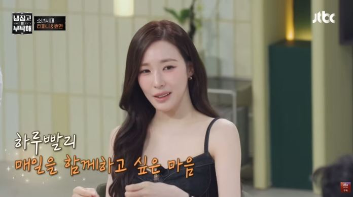 A woman with long hair is sitting at a table, wearing a black tank top, and speaking earnestly. Text in Korean is visible beside her.