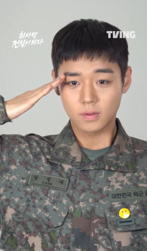 Park Ji-hoon as soldier in military attire giving a salute, with short hair and a neutral expression.