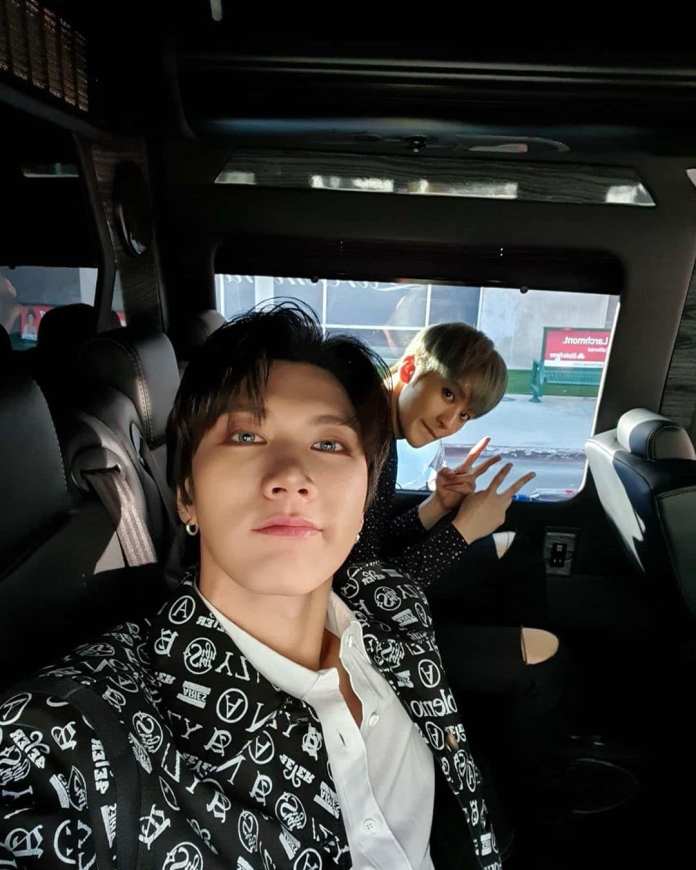 Mark and Ten taking a selfie inside a vehicle, with one smiling directly at the camera and the other playfully posing behind.