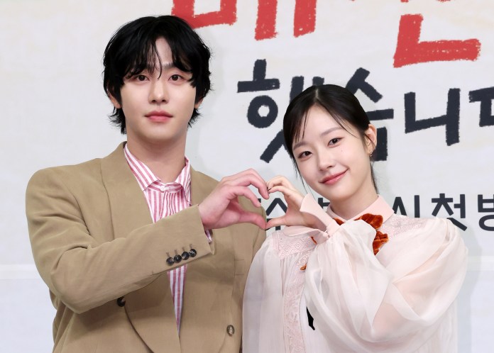 Ahn Hyo-seop nd Chae Won-bin making a heart shape with their hands during a promotional event.