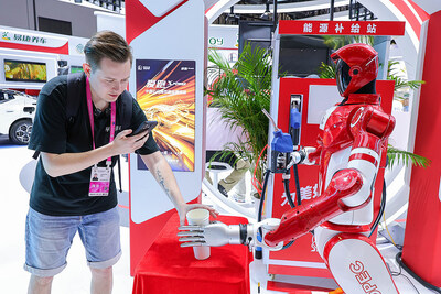 The 6th China International Consumer Products Expo was held on April 13, 2026 in Haikou, Hainan. A variety of intelligent robots were showcased at the expo. The photo shows a foreign livestreamer interacting with a smart service robot.
