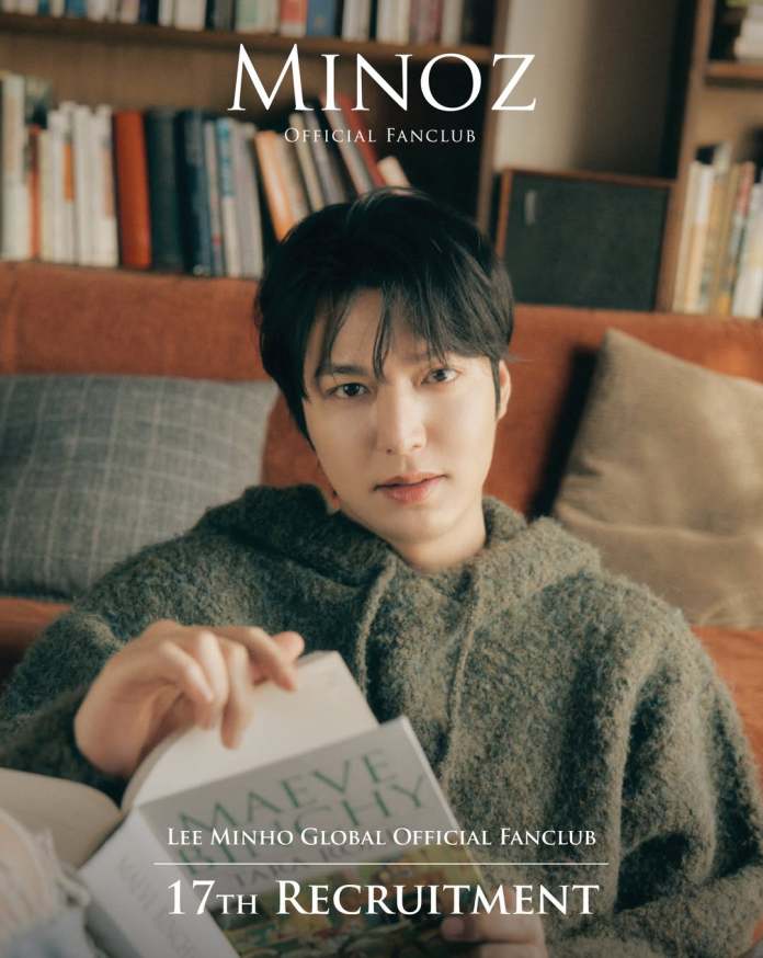 Lee Minho in a cozy sweater sitting on a couch, holding a book and looking at the camera, with a bookshelf in the background. The image promotes the 17th recruitment of the Lee Minho Global Official Fanclub.
