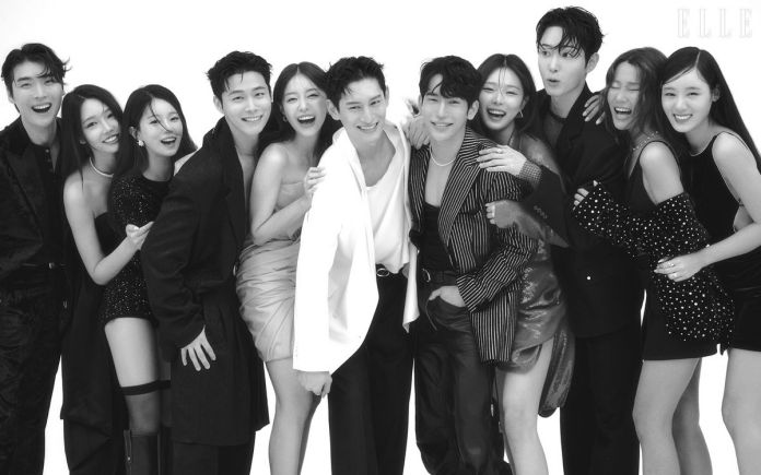 Single's Inferno cast posing together joyfully in a black and white photo, dressed in stylish outfits, with some wearing formal attire and others in chic dresses.