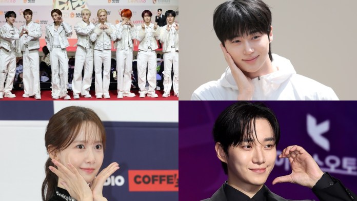 Stray Kids members posing together on a red carpet, all wearing white outfits.