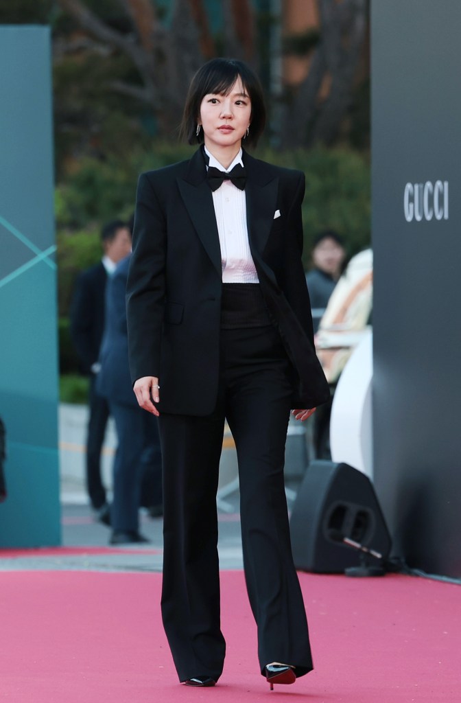 Lim Soo-jung  in a tuxedo with a bow tie walking down a red carpet at an event, with blurred attendees in the background.