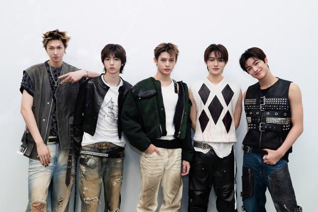 CORTIS performers posing together in fashionable outfits against a neutral background.