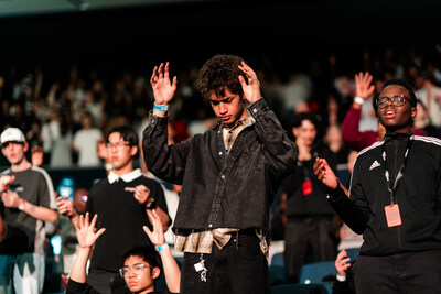Teenagers lifting hands in worship at large worship event at Perth Convention Exhibition Centre