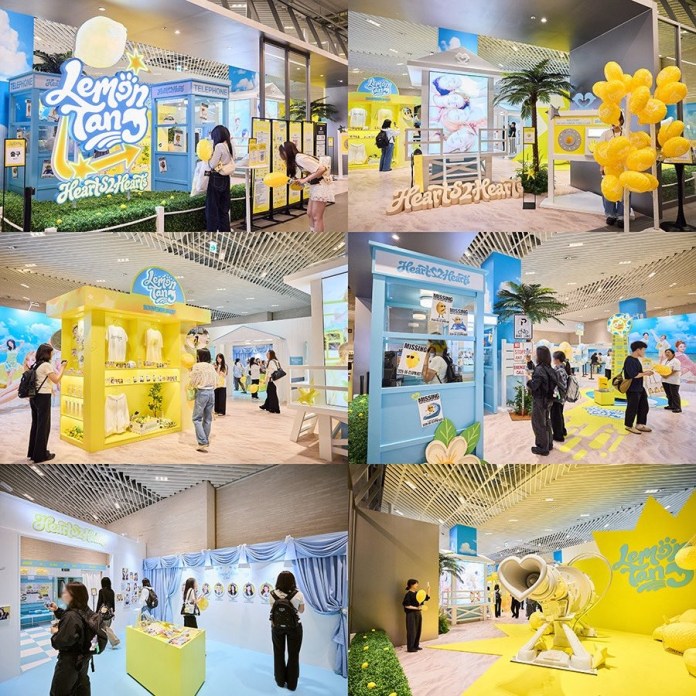 A vibrant exhibition space featuring a 'Lemon Tang' theme, with colorful displays, balloon decorations, and attendees exploring various interactive areas.