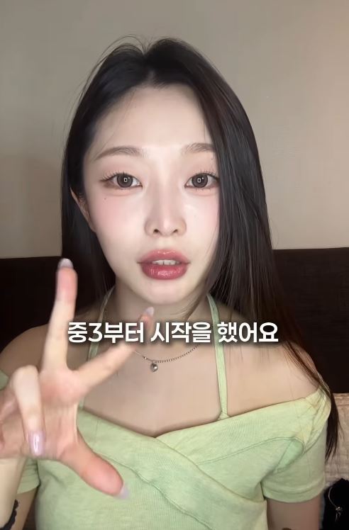 Jung Eun-woo with long hair, wearing a green off-shoulder top, is making a peace sign gesture while speaking to the camera. Text in Korean is displayed below her.