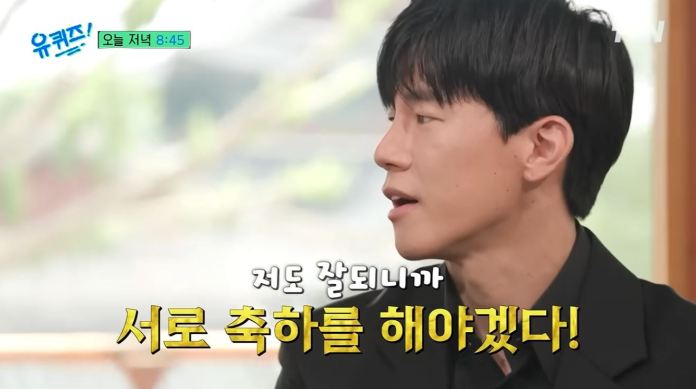  Kim Mu-yeol with dark hair, wearing a black shirt, engaged in conversation. Text overlay in Korean indicates a supportive statement about celebrating each other's successes.