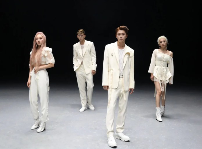 Four individuals dressed in stylish white outfits posing in a dark studio environment.