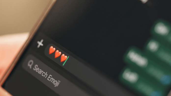 Close-up of a smartphone screen displaying heart emojis with an option to search for more emojis.