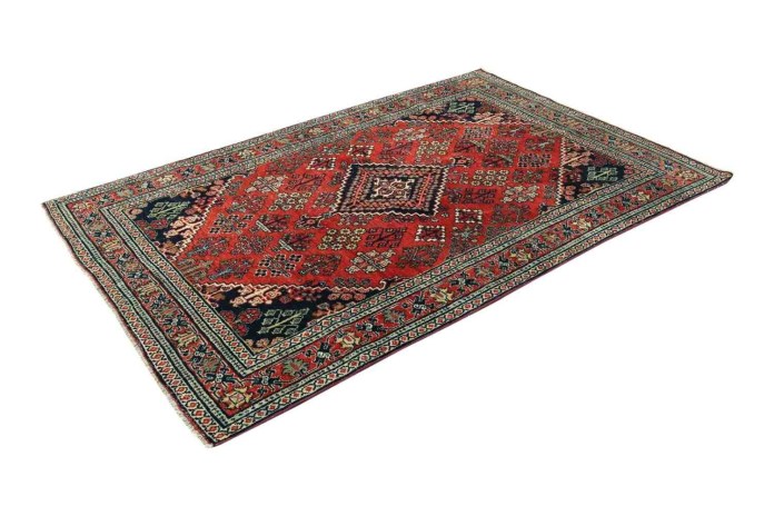A colorful traditional patterned area rug featuring intricate designs in red, green, and blue hues.
