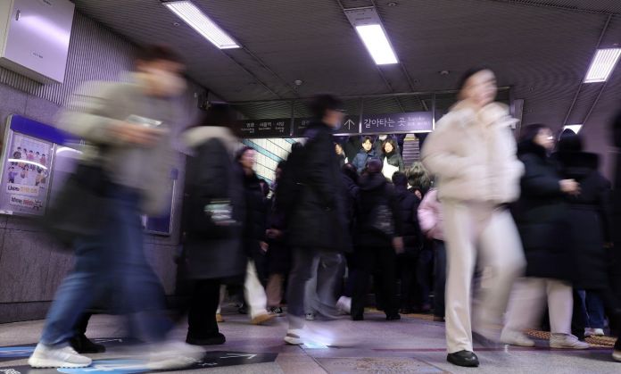 A busy subway station scene with many people walking, some in motion blur, indicating a rush hour atmosphere.