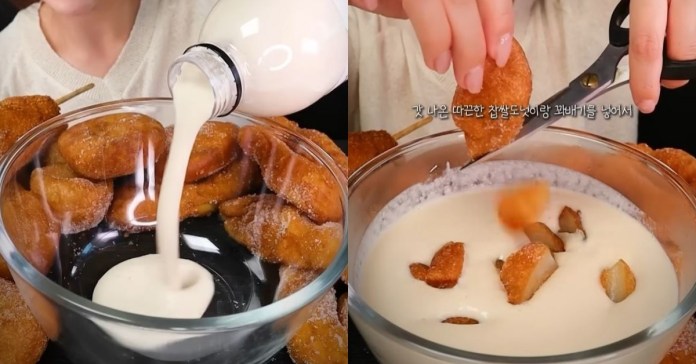 A close-up shot of a bowl filled with fried doughnuts while milk is being poured into it, with a hand cutting a doughnut with scissors.