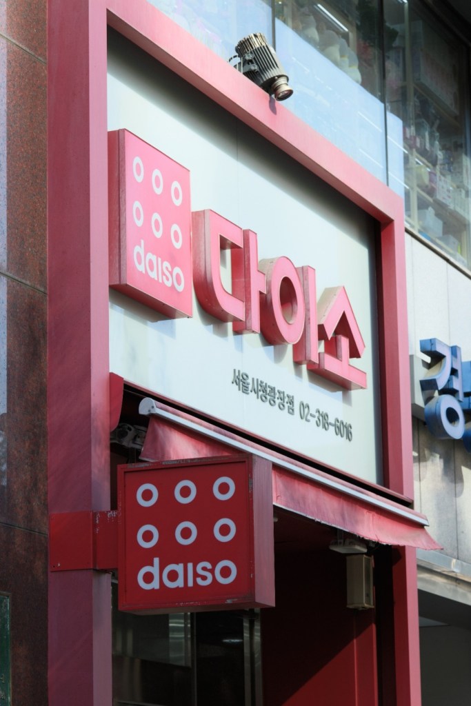 Exterior of a Daiso store featuring the logo and name in Korean and English.