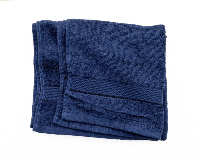 A folded navy blue towel placed on a white background.