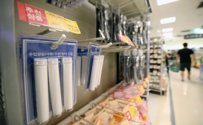 Shelves in a store displaying packets of water filter cartridges, with price tags visible.