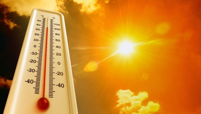 Thermometer displaying high temperatures with the sun shining brightly in the background.