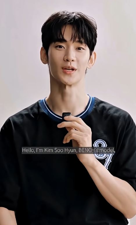Kim Soo-hyun with black hair, wearing a black shirt with a blue collar, introducing himself as Kim Soo Hyun, a model for BENCH.