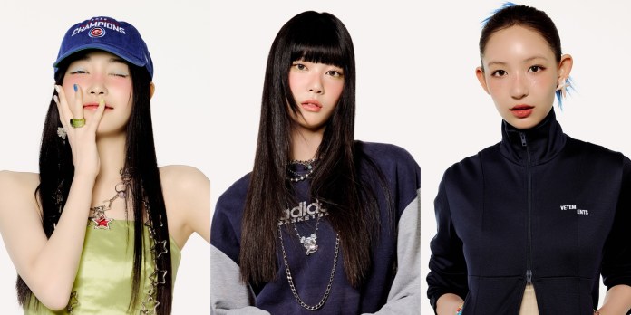 SAKI, SEAH and YIHANI posing stylishly against a plain background. SAKI on the left wears a blue baseball cap and a sleeveless top, holding her hand to her face. SEAH in the center has long black hair and is dressed in a navy sweater, while YIHANI on the right is wearing a dark zip-up jacket and has hair styled with a light hue.