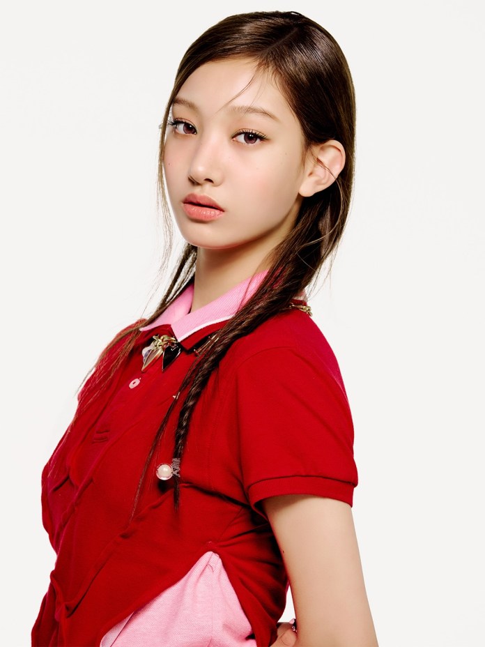 Seoyeon with long, straight hair styled elegantly, wearing a red polo shirt with a pink underlayer. She is looking at the camera with a subtle expression in front of a plain white background.