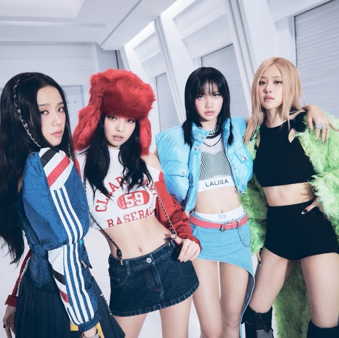 Four elegantly styled women in fashionable outfits posing together indoors with a modern background.