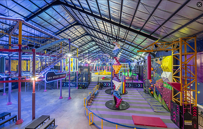 AeroXSpace Adventure Bali offers an all-weather indoor family experience with active play and shared challenges, featuring a variety of attractions including climbing walls and obstacle courses.
