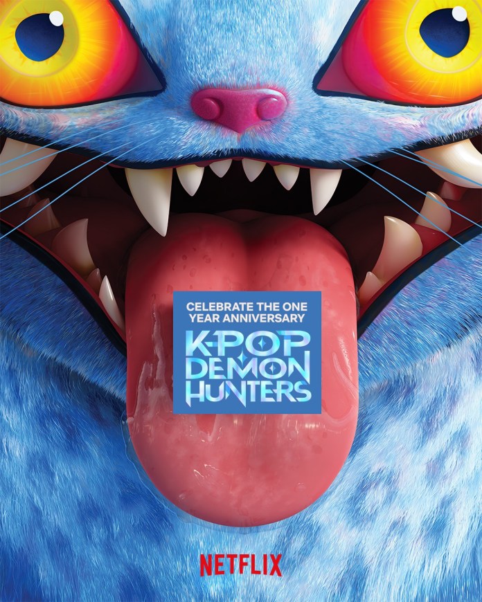 A vibrant and cartoonish blue cat-like creature with colorful eyes and an open mouth, showcasing large teeth and a tongue. It has a promotional banner that reads 'Celebrate the One Year Anniversary K-Pop Demon Hunters' overlaid on its tongue, with the Netflix logo at the bottom.