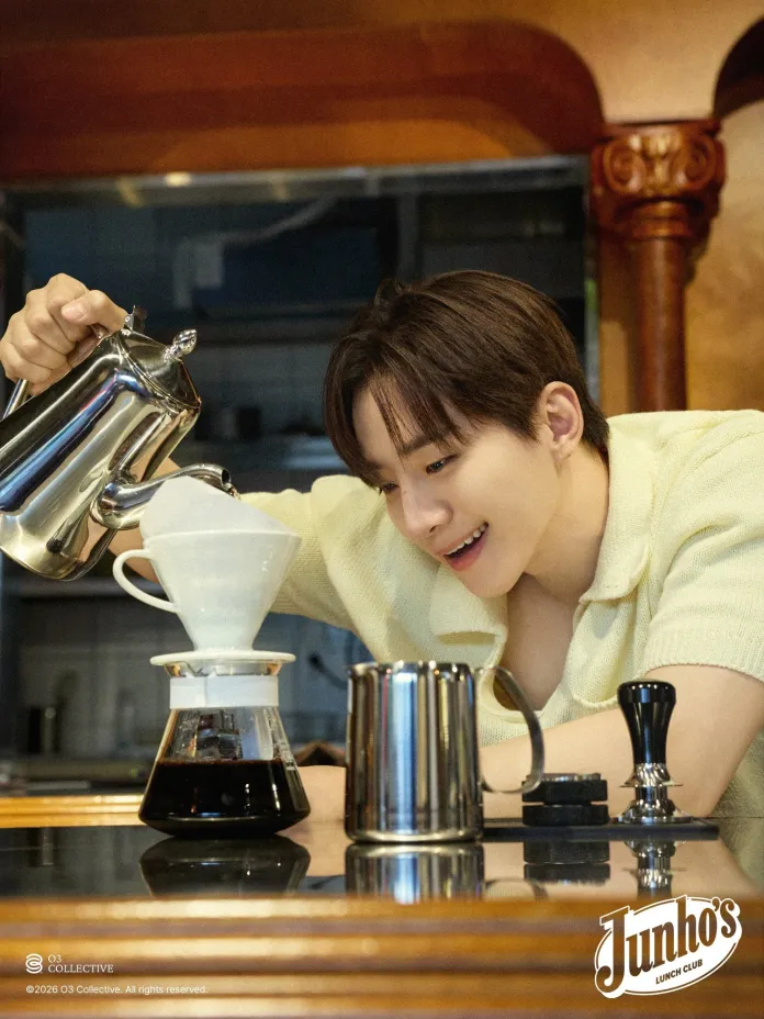 Lee Junho pouring water from a kettle into a coffee dripper, preparing coffee in a cozy kitchen setting.