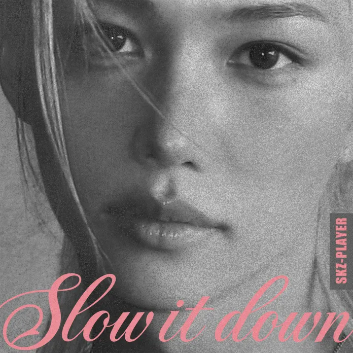 A close-up, black and white portrait of Felix with long hair, featuring the text 'Slow it down' in pink elegant font, and 'SKZ-PLAYER' in the corner.
